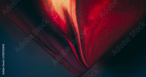 Shiny fluid. Glitter ink. Defocused purple yellow orange color triangle blend sparkling texture spilling on abstract art background.