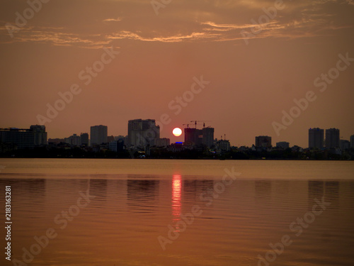 Minimalist Sunset Over Distant Skyline With Glowing Water Reflection on West Lake in Hanoi, Vietnam