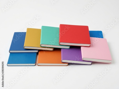 A colorful collection of blank notebooks stacked in a modern arrangement