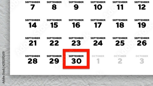 Фотография Close-up of September 30th date marked with a red cursor on a 2026 wall calendar