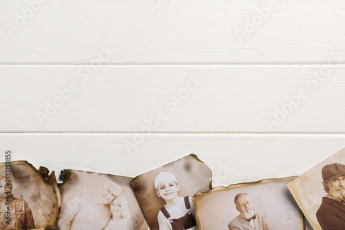 фотографія Old photos of relatives on white wooden background with space for text