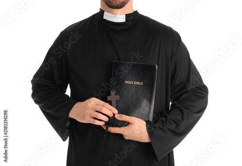 Фотография Young priest with Holy Bible on white background, closeup