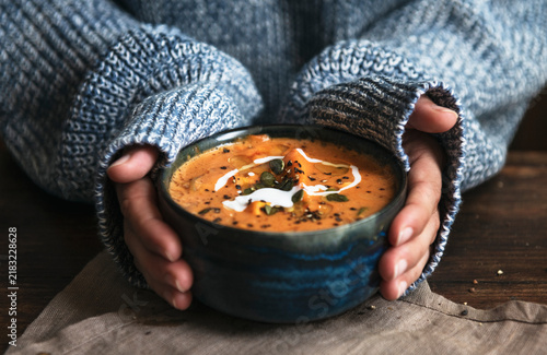 фотографія Female hands holding a bowl of pumpkin soup