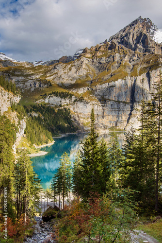 Oeschinensee Kandersteg Swiss Alps Switzerland turquoise mountain lake surrounded by pine forest and steep rocky cliffs