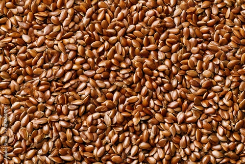Brown flax seeds on a surface, showing texture and detail in close-up view