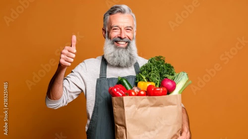 Senior man holding groceries paper bag with healthy food