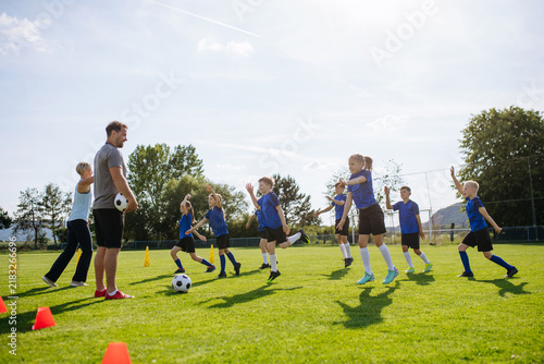 Obraz na plátně Young athletes training footwork and coordination on soccer field