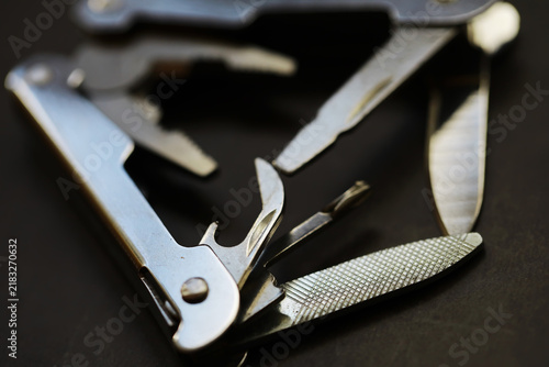 Fotografie Multi-Tool with Blades and Implements on Dark Background for Outdoor and Surviva