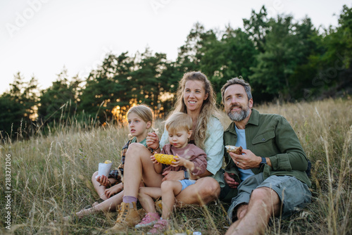 фотографія Family hiking together through countryside during summer camping trip