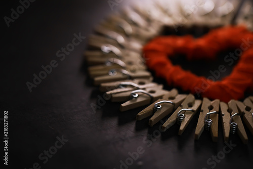 Принти на полотні Heart-Shaped Design with Wooden Clothespins and Red Yarn on Dark Background