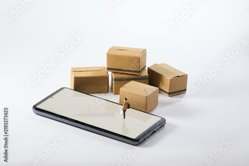 Online shopping concept with smartphone, cardboard packages and miniature person