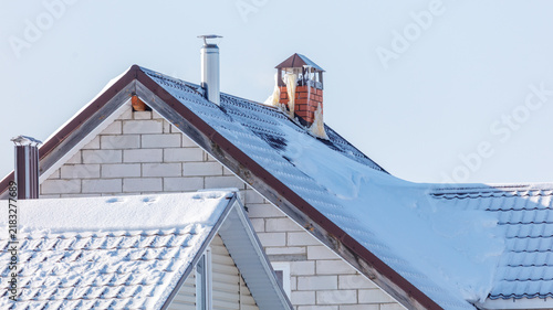 Bild auf Leinwand Snow blankets rooflines under clear sky