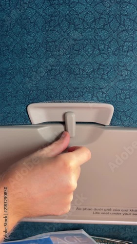 Close-up of a foldable tray table inside a passenger airplane. Travel and aviation concept showing the interior details of an aircraft during a flight.