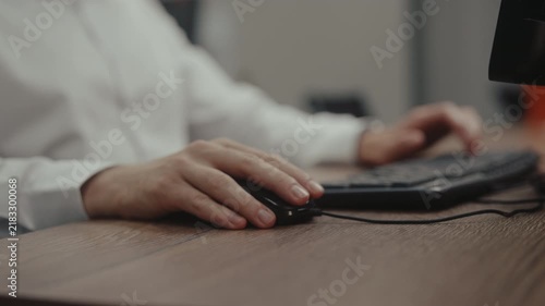 Close-up of man working on computer experiencing sudden wrist pain, stops typing, gestures in discomfort, massages sore joint. Concept of RSI and carpal tunnel syndrome from office work, slow motion.