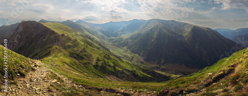 Fotografie Beautiful deep mountain valley stretching between high green ridges