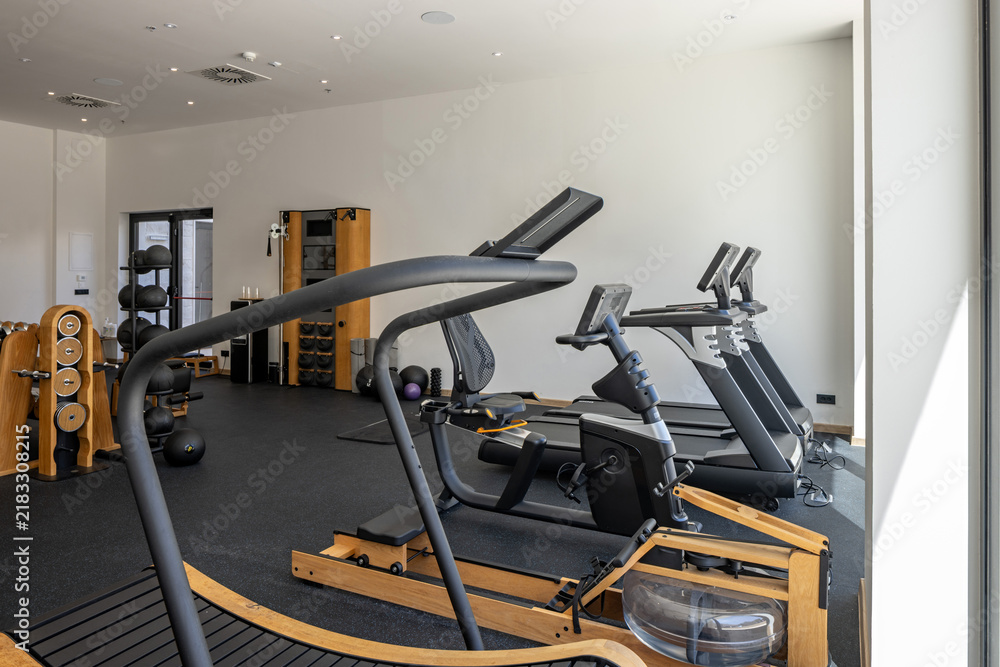 Fototapeta premium Modern hotel gym room with treadmill cardio machines and rowing rower