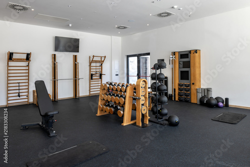 Luxury hotel gym interior with wooden wall bars and fitness equipment