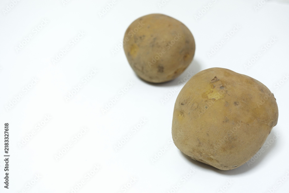 Fototapeta premium Horizontal arrangement of two potatoes on a white, food photo