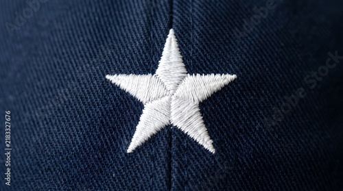 Close up of a white embroidered star on a dark blue textured fabric background