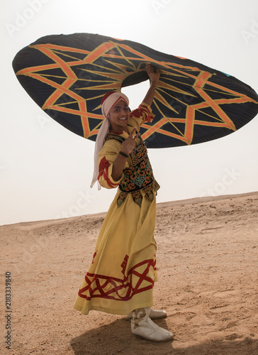 фотографія Joyful young male Egyptian folk dancer spinning a dramatic geometric patterned u