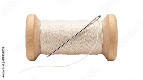 Wooden spool of white thread with needle over transparent background