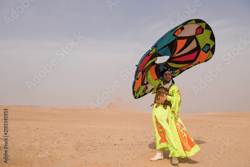 Foto Exuberant Egyptian tanoura performer in neon yellow embroidered robe swinging vi