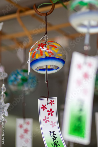 Foto Traditional Japanese Glass Wind Chime Furin with Paper Strip Hanging Outdoors