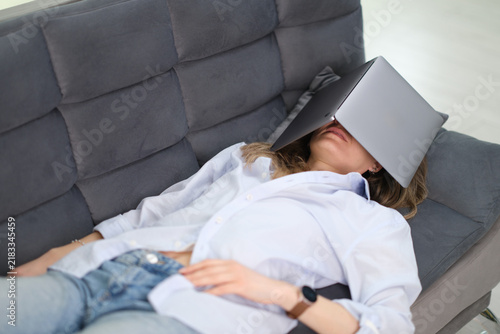 Konstfotografi Tired businesswoman rests on office sofa with laptop put on head covering face