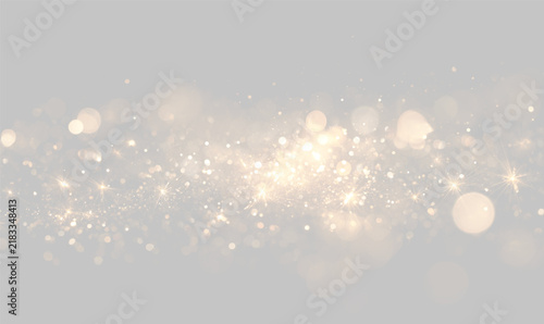Fotografie Golden glitter particles scatter across a dark background with bright sparkling light points
