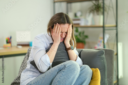 фотографія Stressed businesswoman presses temples while sitting in office armchair