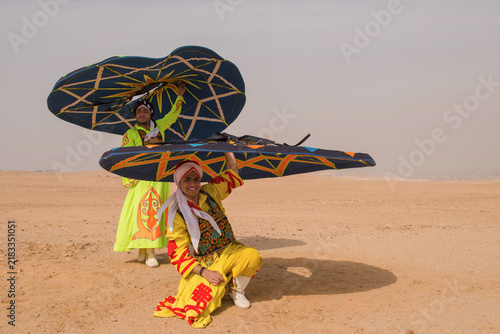 Foto Two smiling kite festival performers in vibrant embroidered folk costumes hold m