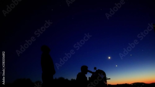 Amateur astronomers observing stars, planets, Moon and other celestial objects with a telescope in nature.
