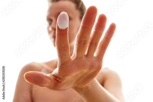 Obraz na płótnie Woman showing beauty cream drop on fingertip for skincare concept