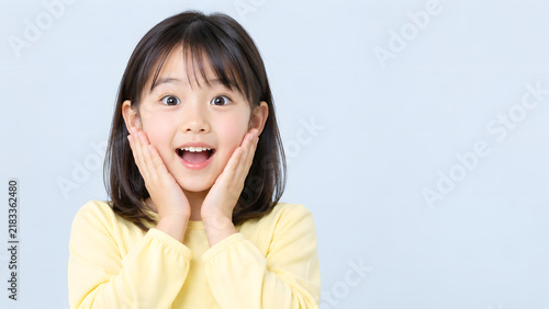 Naklejka 両手を頬に当てて驚く日本人の女の子の表情
