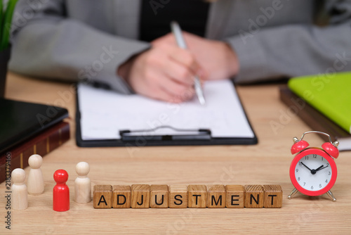 Konstfotografi In a dynamic office scene, wooden letters spell out ADJUSTMENT on a desk
