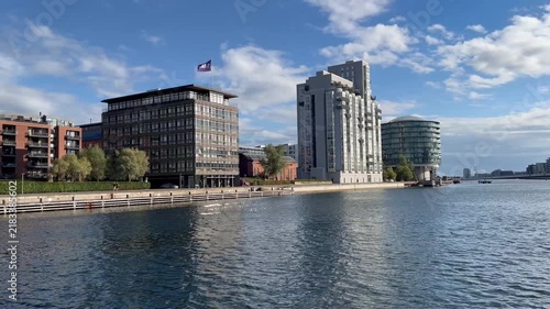 Stunning view from a boat navigating on the canal past the unique Gemini Residence, a converted silo, and passing under the iconic Bryggebroen bridge in Copenhagen on a sunny summer day- stock video