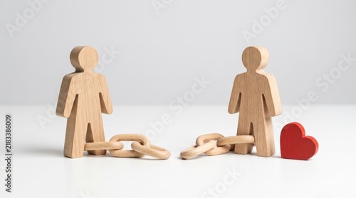 Two wooden figures are connected by broken chains with a red heart beside one figure, symbolizing broken bonds or relationships.