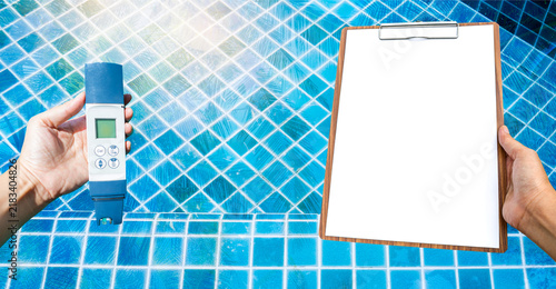 Konstfotografi Digital swimming pool water tester with blank report paper on wooden clipboard o