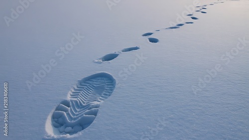 Footprints leading across fresh snow in a peaceful winter landscape