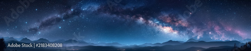 Panoramic view of the vibrant Milky Way galaxy and pink nebulae over a dark mountain range