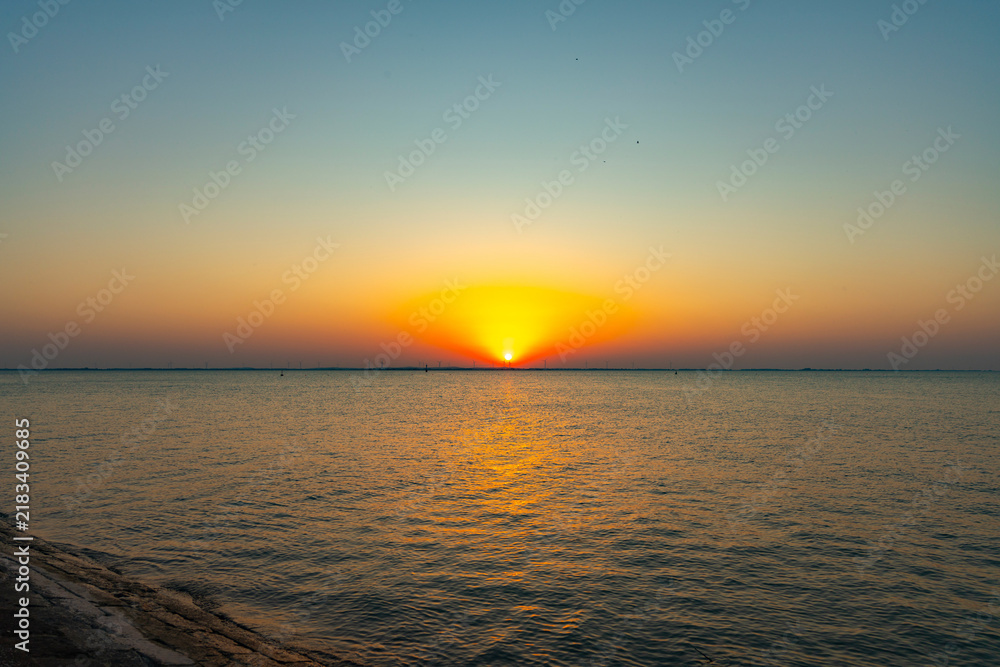Obraz premium Golden Sunset Over Calm Sea
