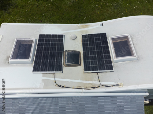 Camper van roof showing installed solar panels and skylights, providing renewable energy for sustainable travel and off-grid living