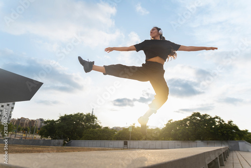 A woman jumps mid-air at sunset in Barcelona Spain