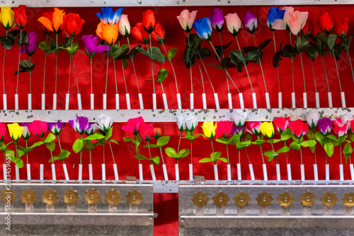 Colorful artificial flowers arranged on display at a local market during a daytime event