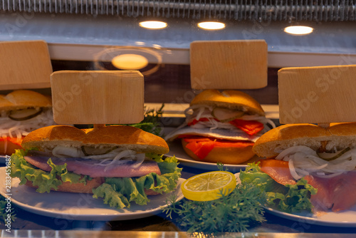 Various sandwiches displayed in a showcase at a food market during the day