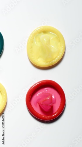 TOP VIEW: Male hand puts a red condom on a white table - Close Up