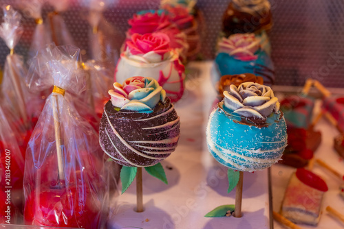 Colorful candy flowers displayed at a market with various flavors and designs