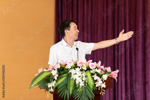Fotografía Man delivering speech at floral podium