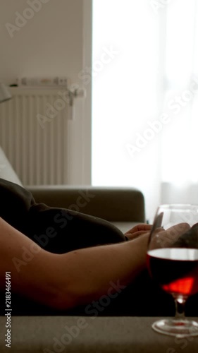 DEPRESSION: Young adult man sleeps while sitting on the couch at home. Alcohol nearby