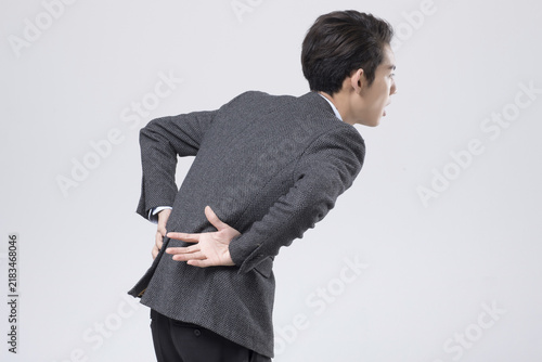 фотографія Man in Suit Clutching Back in Pain